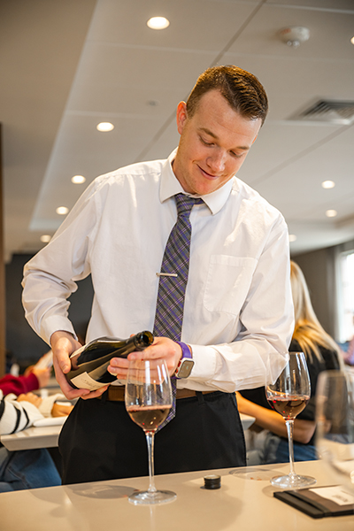 Student pouring wine