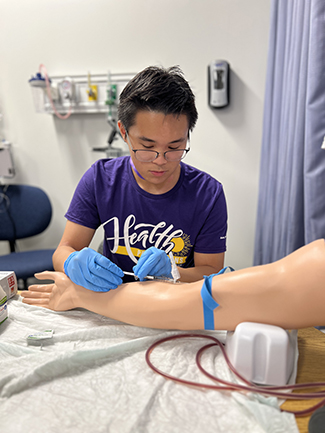 Camper practicing taking blood pressure